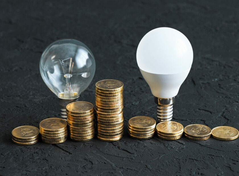 Energy saving. Energy saving light bulb and old bulb.Money coins on a dark background. Energy saving. Stack of coins.Environmental protection